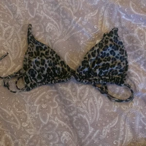 Leopardmönstrad bikini från Good Collection - Snygg leopardmönstrad bikini från Good Collection i återvunnen polyamid. Toppen har knytband för justerbar passform och trekantsformade kupor. Perfekt för en dag på stranden eller vid poolen.