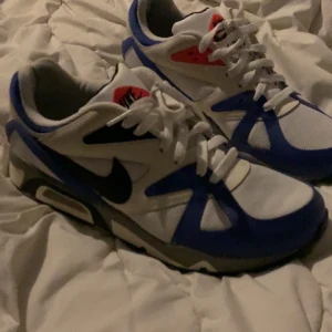 Nike Air structure  - Snygga Nike Air sneakers i en fräsch kombination av vitt, blått och rött. Skorna har en klassisk design med snörning och en bekväm passform. Helt nya nästan oanvända har haft på mig dom max 4 gånger. Ny pris är 1600kr och sälj billigt för att jag personligen inte tycker om dom och fick dom i present. Passar inte min stil därför säljer jag dom. Behöver också pengar till en böter som måste betalas därför är det lågt pris