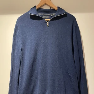 Mörkblå halfzip från Jack and Jones - Snygg mörkblå tröja från Jack and Jones med dragkedja vid halsen. Perfekt för kyligare dagar med sin stilrena design och långa ärmar. Passar både till vardags och mer uppklädda tillfällen.