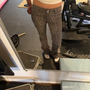 Leopardmönstrade byxor - Snygga byxor med leopardmönster. De har en tight passform och är perfekta för en trendig look. Byxorna har knapp och dragkedja framtill.