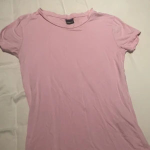 Rosa t-shirt från Gina Tricot - Säljer en tajt rosa tshirt från Gina. Har aldrig använt eftersom jag inte gillar hur den sitter på mig. Väldigt fin rosa färg och pris kan diskuteras.