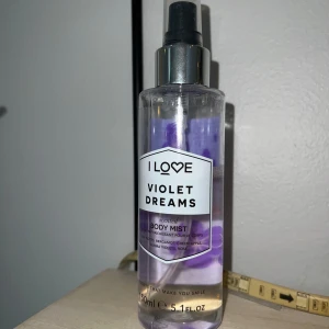 Violet Dreams Body Mist från I Love - Fräsch och blommig body mist med doft av bergamott och viol. Flaskan är genomskinlig med lila detaljer och en praktisk spraypump. Perfekt för en snabb uppfräschning och ger en långvarig doft i upp till 4 timmar. Innehåller 150 ml. 2/3 kvar av flaskan. se bild