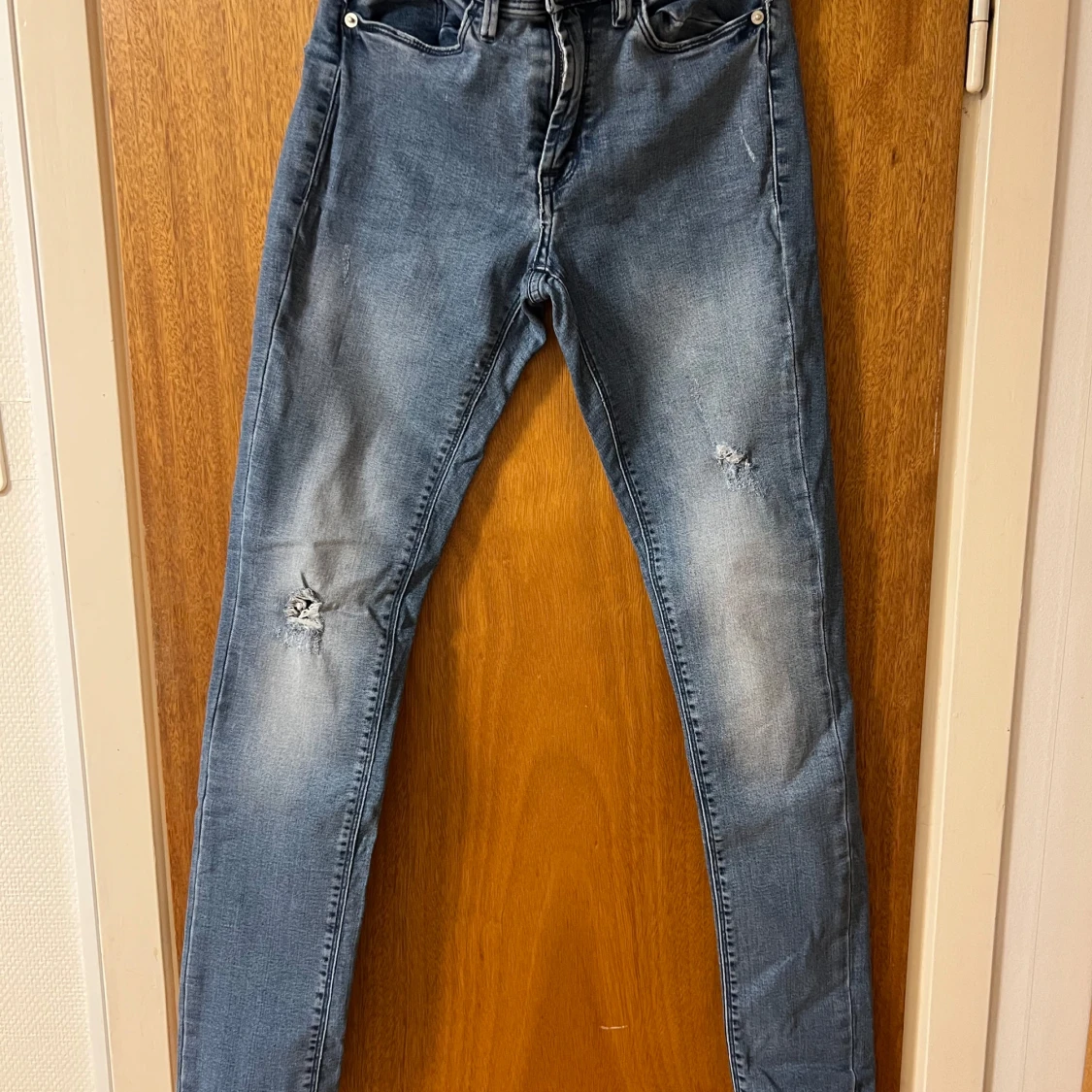 Blå jeans med slitningar