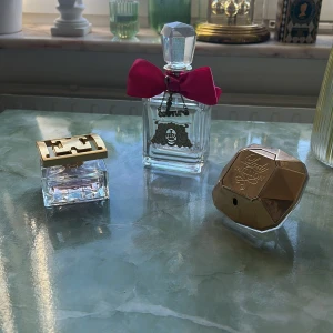 Parfymer från Escada, Juicy Couture och Paco Rabanne - Tre eleganta parfymer: Escada i en fyrkantig flaska med guldlock, Juicy Couture i en flaska med rosa rosett och kristalliknande lock, samt Paco Rabanne i en diamantformad flaska med guldlock. Perfekta för att ge en lyxig touch till din doftsamling. Escadan är nästan full, de andra två har lite kvar. 