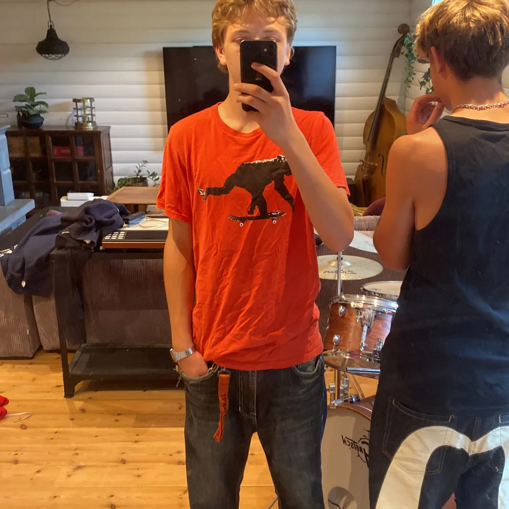 Säljer en cool orange/röd t-shirt från Volcom med ett unikt tryck av en apa som åker skateboard. T-shirten är kortärmad och i bomull, perfekt för en avslappnad stil. Volcom-loggan finns tryckt på ärmen. Passar perfekt för skate eller vardagsbruk!. T-shirts.