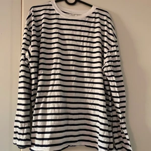 Randig långärmad tröja från 157 - Säljer en klassisk randig tröja från lager157 i storlek XL. Den är vit med svarta ränder och har långa ärmar. Perfekt för en avslappnad stil och gjord i 100% bomull för extra komfort. Passar både till vardags och lite mer uppklädda tillfällen. Hör gärna av er vid frågor eller fler bilder💕