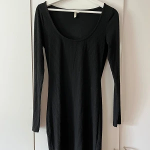 Svart klänning - Figurnära klänning i ribbat material, sitter jättefint på Slutar ovanför knäna på mig som är 1,62
