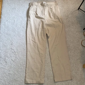 Beiga/vita kostymbyxor från Part Two  - Hej!!  Jag säljer nu dessa kostymbyxor då det inte är min stil. Använda endast en gång.  Nypris: 1200 Skick: 10/10