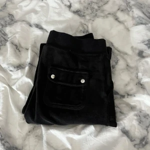 Svarta mjukisbyxor med fickor - Säljer ett par svarta juicy couture byxor i skönt material. De har en avslappnad passform med snörning i midjan och praktiska fickor både fram och bak. bilderna är lånade! hör av er för egna bilder eller frågor💕storlek XS passar S
