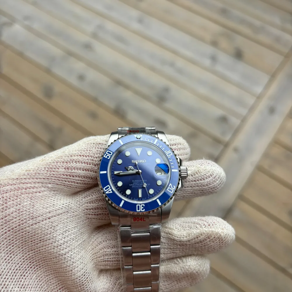 Tja! Ännu en fin Seiko Submariner Mod. Denna är smurf modellen vilket betyder att den är blå! Super fin klocka. Helt ny och inplastad. NH35 Automatisk Seiko rörelse. 904L Stainless steel. C3 Lume (lyser i mörkret). Sitter på en Oyster länk.. Accessoarer.