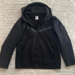 Nike tech svart - Säljer nu mitt svarta Nike tech i storlek S. Den e lite solblekt på luvan över lappen om ni ser på bilden annars är tröjan i bra skick