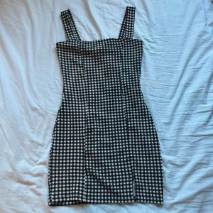 Rutig mini dress - Söt känning som ej kommer till användning. Sitter tight på kroppen, liten sökt vid ena benet.