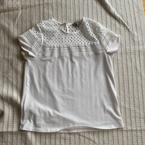 Vit T-shirt med brodyr - Vit T-shirt med brodyr. En bra basic som även kan användas som lite finare kläder. Perfekt skick.