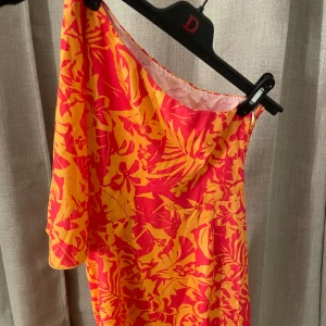 Klänning - One shoulder klänning, med en ”snevolang”. 