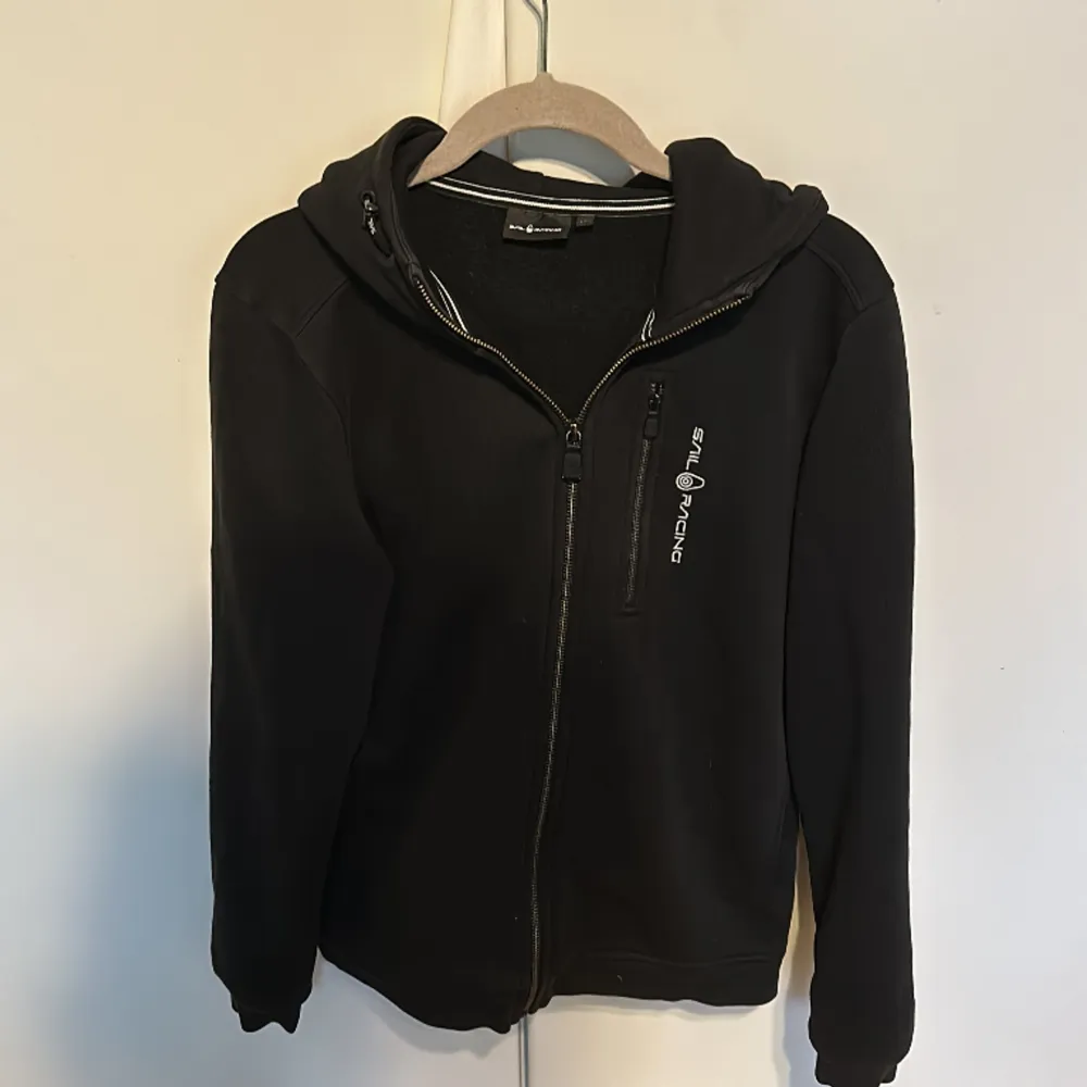 Säljer denna sail racing zip hoodie då jag har växt ut den. Använd ett par gånger men annars i super skick. Färgen på dragkedjan har försvunnit lite men det märker man inte. Priset kan diskuteras!. Hoodies.