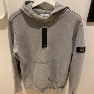 Stone island hoodie - Stone Island hoodie i bra skick! Finns en liten flaw på armen - se bild 3. Storlek: Junior 170 men passar S och en liten M. Givetsvis äkta med tags! Pris kan diskuteras!
