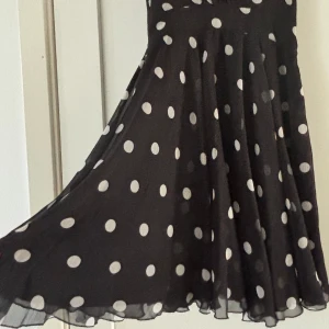 Svart klänning vita prickar  - Klänning  storlek S med fint falll. Perfekt till festen. Inga anmärkningar. 