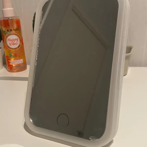 Sminkspegel  - En liten söt Sminkspegel. Kan ljusas up men du behöver en speciel laddare till det dock, har en mini ytte bytte spricka vid vänstra kanten. Storlek : höjd : 17cm bredd: 12 cm