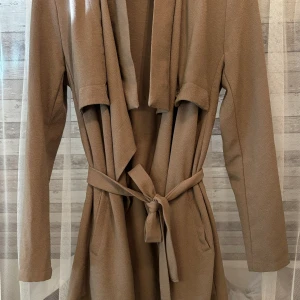 Ljusbrun kappa - Använd ett fåtal gånger  Väldigt fin färg Tunn och perfekt för sommarkvällar, vår och höst.