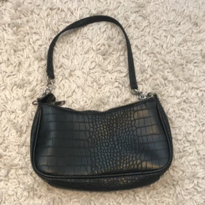 Väska - Säljer denna Axel väska nu. Säljer för att den aldrig kommer till användning mer. Den är ifrån glitter för ca 2-1 år seden. Den är i fint skick och endast använd ett par gånger! 