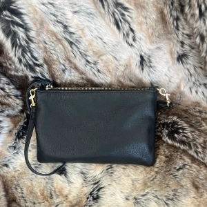 Svart axelväska med guldiga detaljer  - Väska från DAY ET. Axelbandet är justerbart. Ganska liten men får ändå plats med mycket. Det finns också 3 ”korthållare” i. 