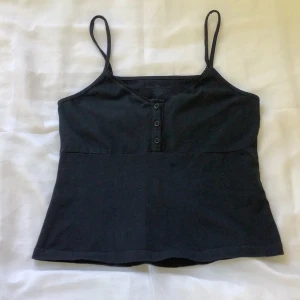 Svart linne💕 - As snyggt linne från brandy Melville med knappar längst upp i storlek one-size (XS-S)❤️‍🔥 Kom privat för frakten, och hela betalningen sker via swish!