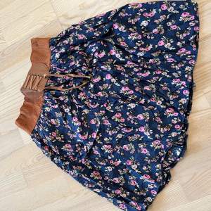 Blommig kjol motsavara M/L med lätt underkjol och brunt sydd typ bälte upptill