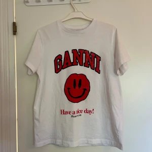 Ganni tröja med rött tryck - En vit ganni tröja med rött tryck. Säljer för den är lite för stor och kommer därför inte till användning💕💕
