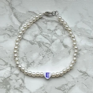 Pärlarmband ”E” - Handgjort pärlarmband med bokstaven ”E” 💜 35 kronor! Silvermedaljer Köp via köp nu eller privat för 18 kronors frakt (frimärke)