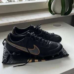 Nike tiempo fotbollsskor - Nike tiempo fotbollsskor svart och guld. Ny pris 2700. Aldrig annvända, nyskick. Stl 43, 27,5cm