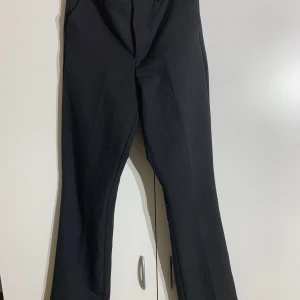 Svarta kostymbyxor  - Ett par svarta utsvängda mid/high waist kostymbyxor från bikbok. Midjemått: 60cm. Innerbenslängd: 80cm. Sparsamt använda. Pris kan diskuteras!