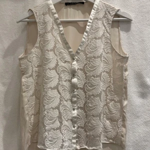 Ljus cremefärgad topp - Fin topp från Zara.  Framsida i brodyr, knappar med strass och hel baksida.   Strl: S