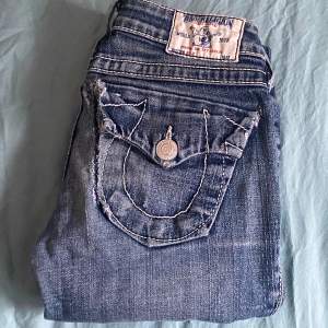 Jag säljer mina Bootcut, lågmidjade, true religion jeans då de inte passar min stil längre:) Finns deffekter som slitning längst ned och ett ihop sytt hål vid ena fickan. Säljer därför billigt! Innerbenslängd: 73 cm, midjemått rakt över: 31 cm