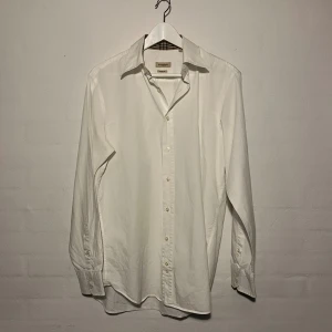 Burberry Skjorta - - Märke: Burberry - Färg: Vit - Storlek: L i slim fit - Skick: Bra skick inga skador eller defekter 9/10  Nypris: 5000kr Vårt pris: 1250kr Skriv om ni är intresserade eller har frågor!! Tveka inte!!