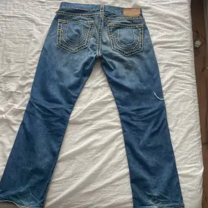 Jätte coola True Religion Jeans, de är köpta i butik för inte länge sen och har inga defekter vad jag kan hitta, de är i stl:34 och är lite långa i bena på mig som är 171cm, rak modell i jeansen. Köparen står alltid för frakt🥰❤️(skriv för fler frågor)