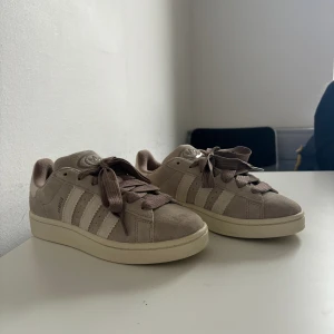 Adidas Campus 00S beige  - Inköpta från merchsweden, kvitto finns. Ingår även ett par vita skosnören. Endast använda en gång men tyvärr för små för mig. Superfint skick och supersköna. Skickas spårbart med postnord alt hämtas i Gävle. St 38 2/3. 
