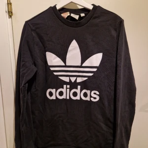 Tröja från adidas  - Svart tröja med vitt tryck från adidas. Passar en storlek S/M