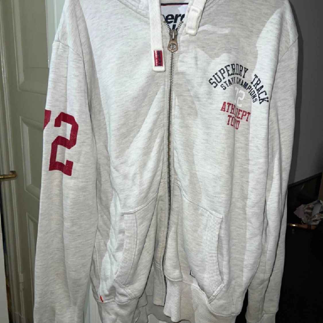 Vit/ljugrå melerad hoodie.