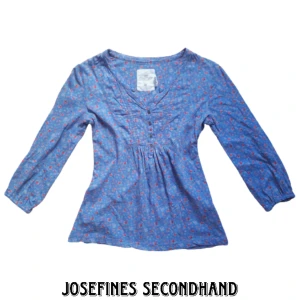 Blå söt blus med blommigt mönster - Blå långärmad blus från H&M i mönster av röda blommor och knappar. Är i använt skick. Använd gärna köp nu/prisförslag funktionen