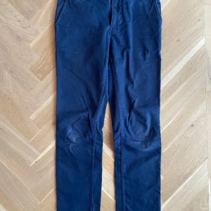 NN07 Chinos Marco Mörkblå 29/32 - Använda men i bra skick. Upplagda några centimeter. Passade mig som är 171cm lång. Midja 29 längd 32 från början. Har flera färger. De övriga annonser. 