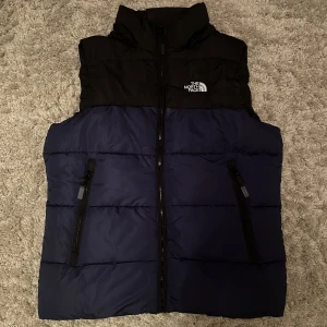 Dunväst - Dunväst märkt northface i bra skick, med resår och avtagbar luva. Kan ej garantera äkthet då tagg saknas (se bild 3) , storlek: L
