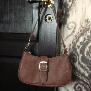 Bikbok y2k väska - Snygg y2k väska från bikbok i fejk läder, typ aldrig används. Ser liten ut men det finns plats för mycket i den! Säljer eftersom jag aldrig använder den, inga fäckar eller märken den är super fräsh! 