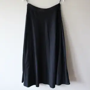 Svart kjol storlek 40 (M) från Nanso. Längd: ca 84 cm. Midja: 35 cm x 2 med resår i midjan. Har två fickor fram!