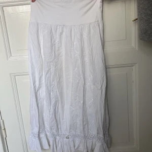 Vit maxikjol - Superfin vit maxikjol med broderier💓stretchig midja! Passar nog XS/S, bra längd för en person under 167 om man vill ha den hellång. Fint skick bortsett från ett litet hål längst ner på baksidan (därav priset), se bild. 