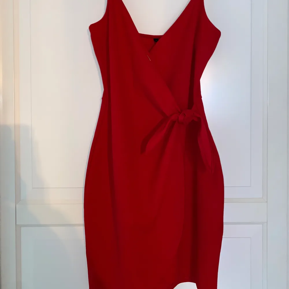 Röd klänning med knyte i sidan. Använd fåtal gånger.. Klänningar.
