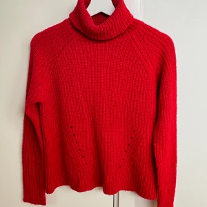 Stickad tröja - Stickad tröja med hög hals som man viker ner. Använt skick, lite nopprig/luddig (se sista bilden), därför säljs den billigare :)