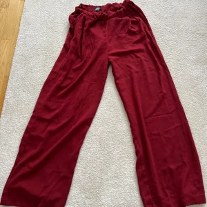 Vida byxor  - Röda vida byxor i tunt somrigt materialet.   Endast använda 2-3 gånger, säljer pga att dem blivit försmå.