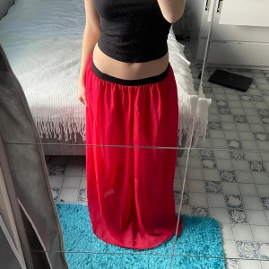 Röd långkjol - Söt lång kjol till sommaren, säljer även en likadan orange. 100 cm lång, jag är 160 cm för referens. Väldigt stretchigt resårband i midjan, vilket gör att den passar dig om du är mellan xs-m (jag är xs). Finns ingen lapp i, så det står inte storlek