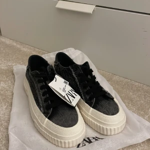 Gråa Sneakers  - Gråa/svarta snygga sneakers med glitter detaljer på sidorna. De är även slut på Zara.