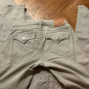 True religion  - Lågmidjade ljusgråa true religion byxor, superfint skick. Inga fläckar, hål eller liknade utan topp kvalitet. Sitter superfint på och formar kroppen. På mig sitter dom (tight) ner till. Xs-m funkar beroende på hur du vill jeansen ska sitta